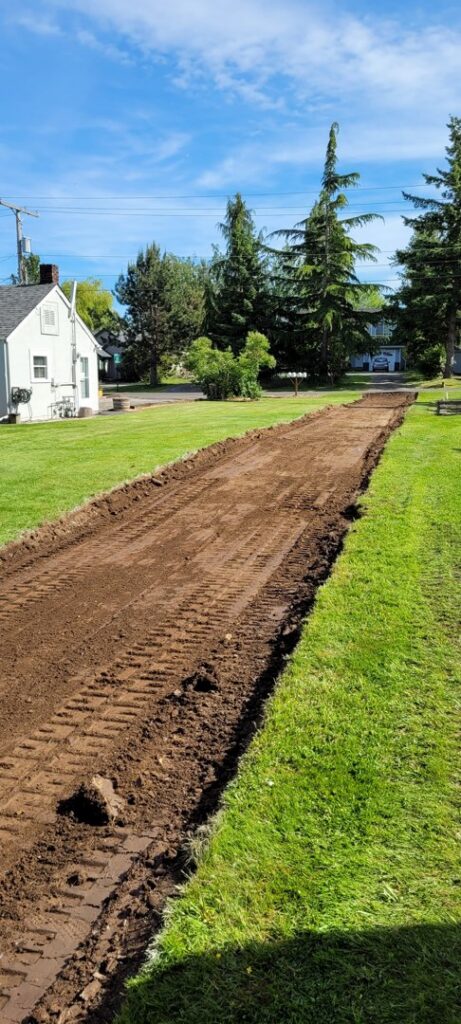 A long strip of land cleared and graded, demonstrating site preparation services by ROUGH 2 READY in Auburn, AL