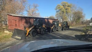 A skid steer loading salt into a pickup truck's salt spreader for de-icing services by TPM Snow Removal in Schenectady, NY.