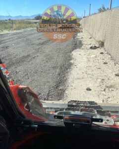 An operator's view from a skid steer performing grading and site preparation for Solid Scoops Construction in Tucson, AZ.