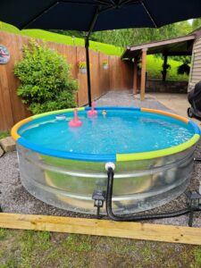 A small round stock tank pool with a connected pump system installed by Pool Queen in Fairmont, WV.