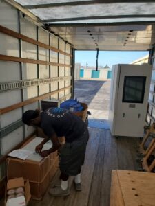A SNEEDWORKS mover organizing boxes and items inside a moving truck at a storage facility in Oklahoma City, OK.