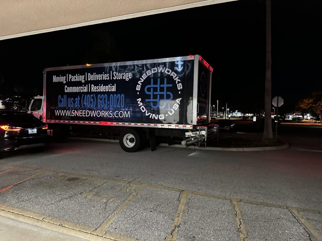 A SNEEDWORKS moving truck parked at night, ready for or completing a moving service in Oklahoma City, OK.