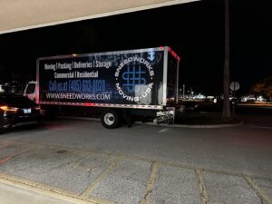 A SNEEDWORKS moving truck parked at night, ready for or completing a moving service in Oklahoma City, OK.