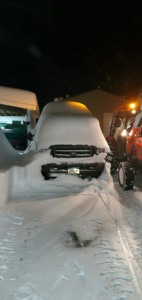 A snow-covered truck and a tractor with a plow ready for snow removal at TPM Snow Removal in Schenectady, NY.