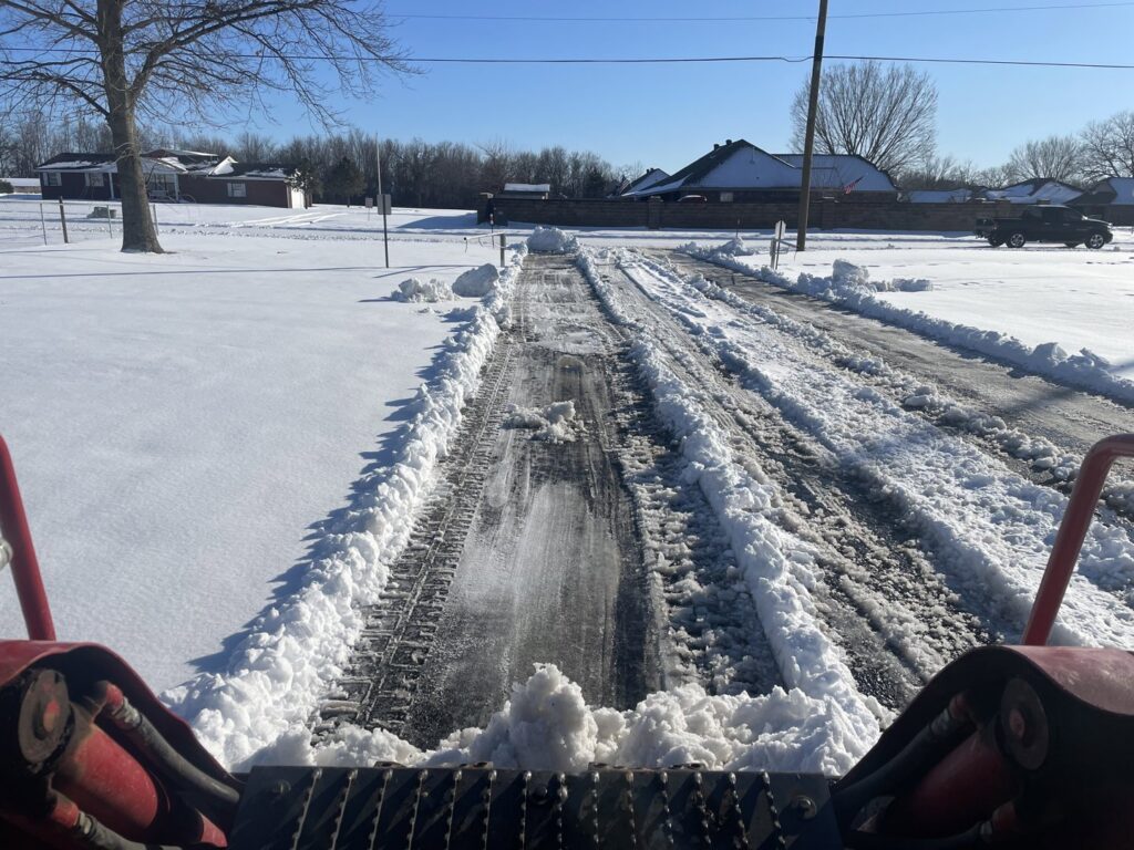 View from a snow plow clearing a residential driveway for Bridgewood Landscape in Rogers, AR.