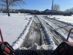 View from a snow plow clearing a residential driveway for Bridgewood Landscape in Rogers, AR.