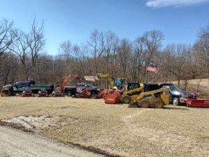 Mr. Frosty Snow Removal's fleet, including a branded truck and a skid steer with a snow plow, ready for service in Springfield, IL.