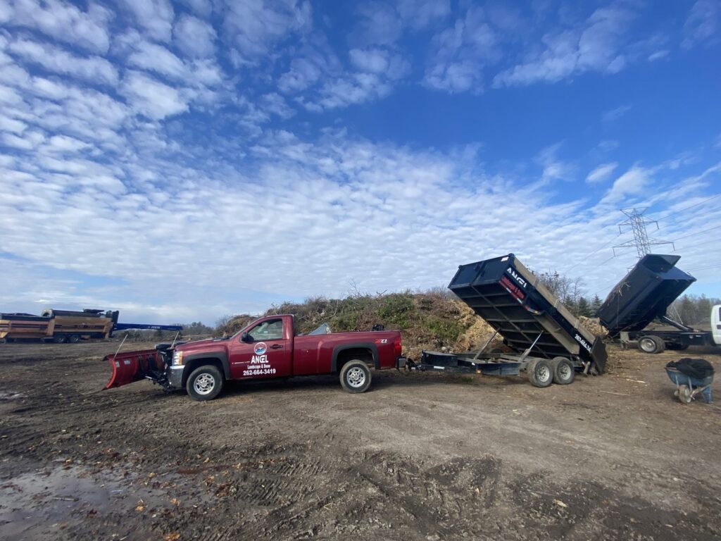 A red pickup truck equipped with a snow plow for snow removal services by Angel Landscape & Snow Services Inc. in Racine, WI.