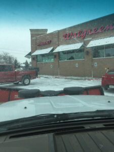 A snow plow truck from TLC Lawn Care and Snow Removal LLC ready to clear a Walgreens parking lot in Colorado Springs, CO.