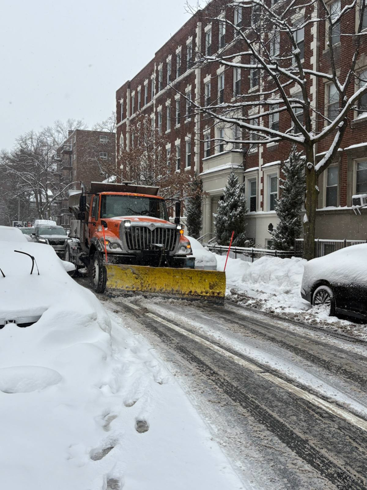 A snow plow truck clearing a residential street of snow for the City of Cambridge Department of Public Works in Cambridge, MA.