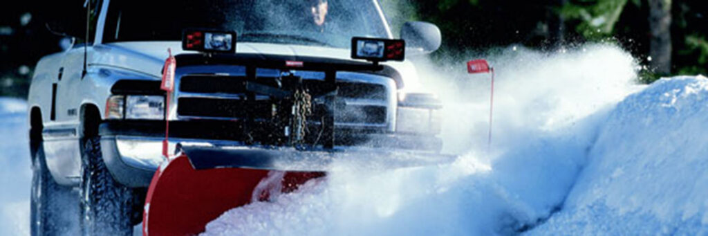 A snow plow truck actively clearing a large amount of snow, demonstrating snow removal by Snow Doctors in Sioux City, IA