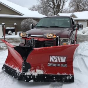 A red pickup truck equipped with a Western snow plow, ready for snow removal services by Spindrift Lawn & Snow in Iowa City, IA.