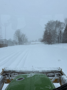 View from a tractor cab showing snow plowing in progress by Pro Cut Lawn Services in Green Bay, WI.
