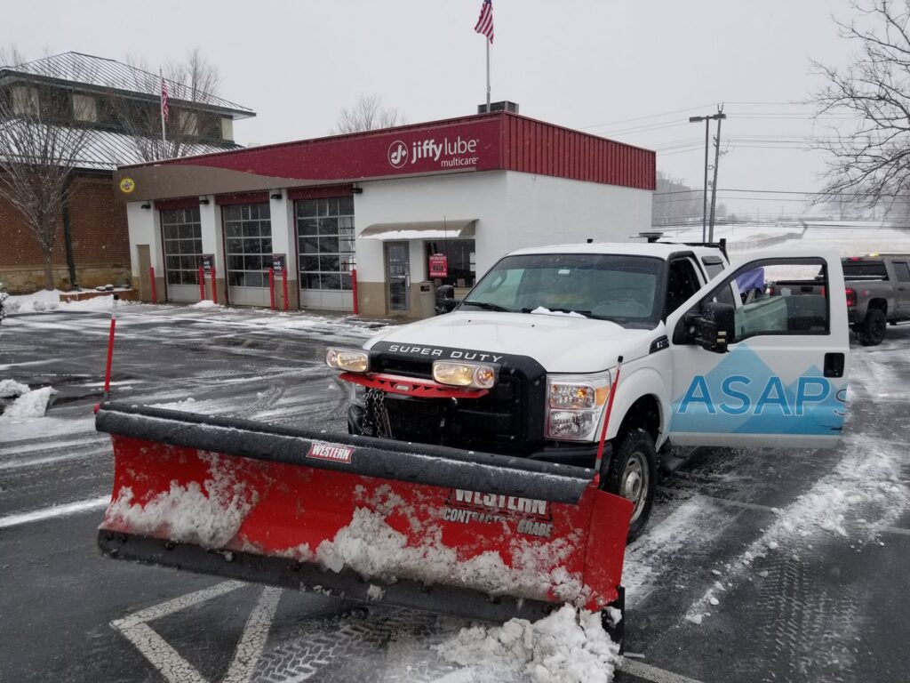 A snow plowing truck with snow on its plow, indicating a recent job by American Snow Plowing Services in Rockville, MD.