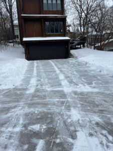 A residential driveway after a snow removal job by Snow Scholars - Snow Removal By College Students in Madison, WI.