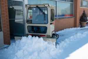 A snow removal machine clearing a path in front of a building for Lawn Performance, LLC in Albany, GA