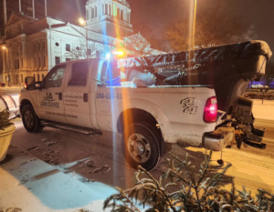 A JA Lawn Service, LLC snow removal truck with a plow and salt spreader parked on a snowy street in Fort Wayne, IN.