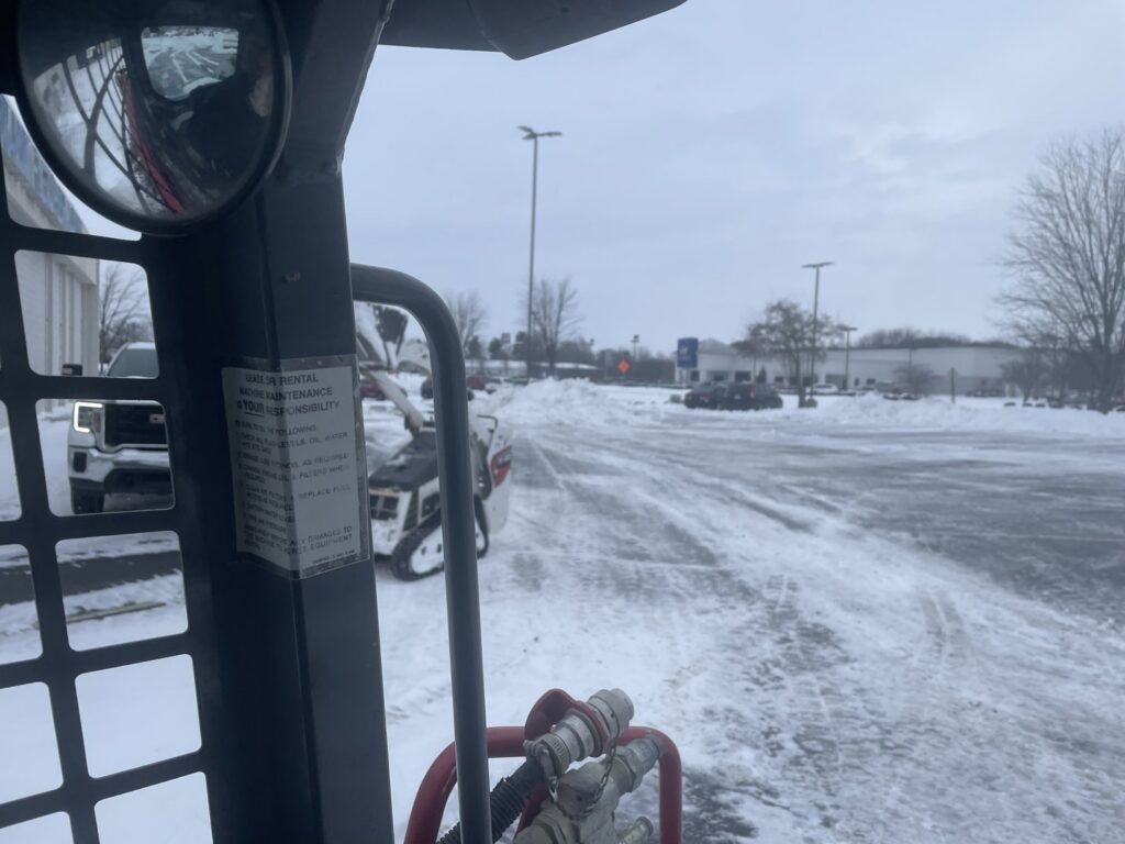 A snow removal vehicle clearing a commercial parking lot for Bridgewood Landscape in Rogers, AR.