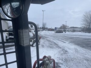 A snow removal vehicle clearing a commercial parking lot for Bridgewood Landscape in Rogers, AR.