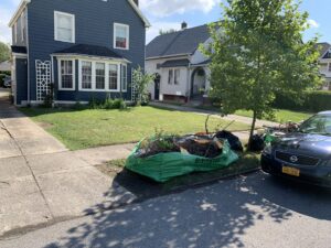 A snowplow truck with its blade down, actively clearing snow from a road for Knight's Landscaping & Snow Removal in Buffalo, NY.