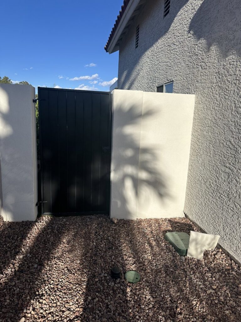 A solid black pedestrian gate installed by Giddy Up Garage Doors & Iron in Las Vegas, NV.