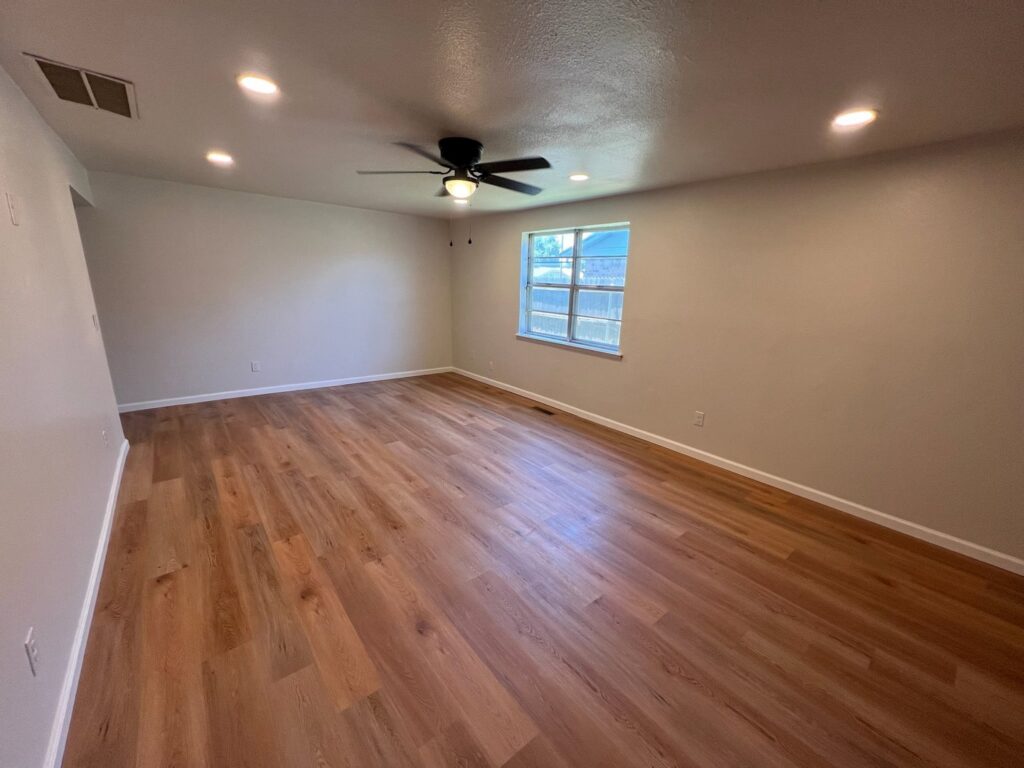 A spacious, clean living room with wooden floors and recessed lighting, demonstrating Krys Cleaning's quality in Oklahoma City, OK.