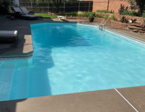A sparkling clean backyard swimming pool, showcasing professional pool cleaning by AquaDocs in Dublin, OH.