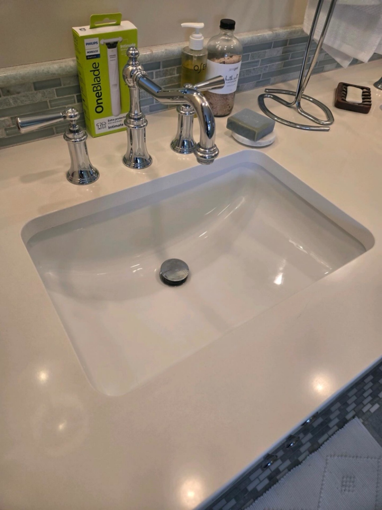 A sparkling clean bathroom sink and countertop, showcasing the meticulous work of Polished Housekeeping Services in Londonderry, NH.