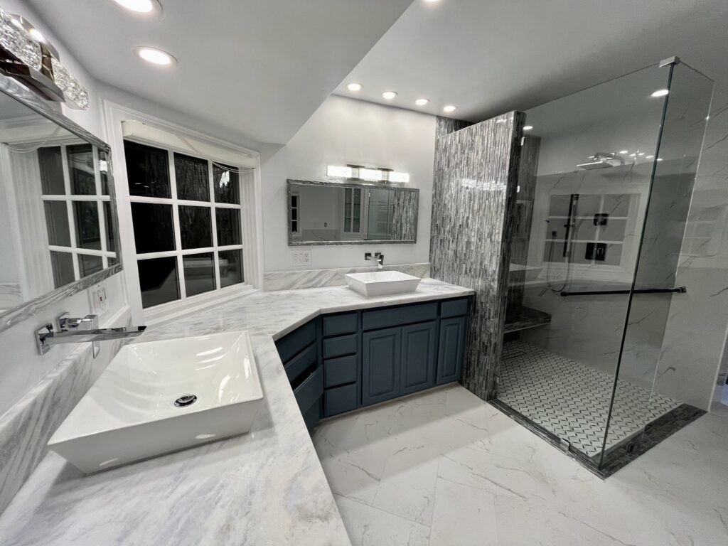 A sparkling clean modern bathroom with double sinks and a glass shower, expertly cleaned by Glisten Co Cleaning Service in Worcester, MA.