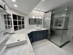 A sparkling clean modern bathroom with double sinks and a glass shower, expertly cleaned by Glisten Co Cleaning Service in Worcester, MA.
