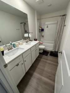 A sparkling clean bathroom featuring a double vanity and shower, cleaned by Saari's Cleaning Services LLC in Jacksonville, FL.
