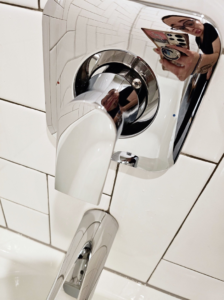 A sparkling clean chrome bathroom faucet and white subway tiles, showcasing quality cleaning by Mountain Life Services LLC in Colorado Springs.