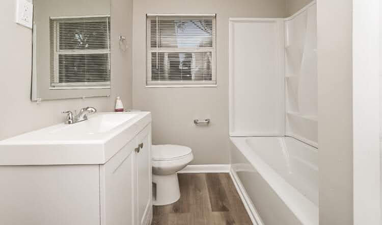 A sparkling clean bathroom with a white vanity and bathtub, showcasing the professional cleaning services of Perfection Cleaning in Kansas City, MO.