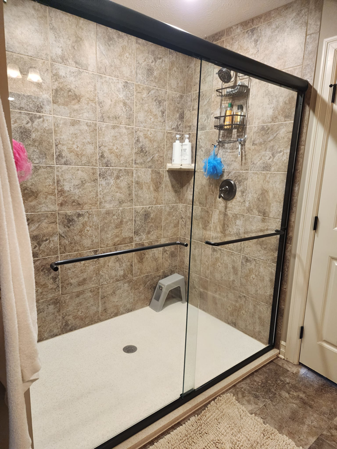 A sparkling clean bathroom shower with glass doors and tiled walls, maintained by Yeilys Cleaning Services LLC in Omaha, NE.