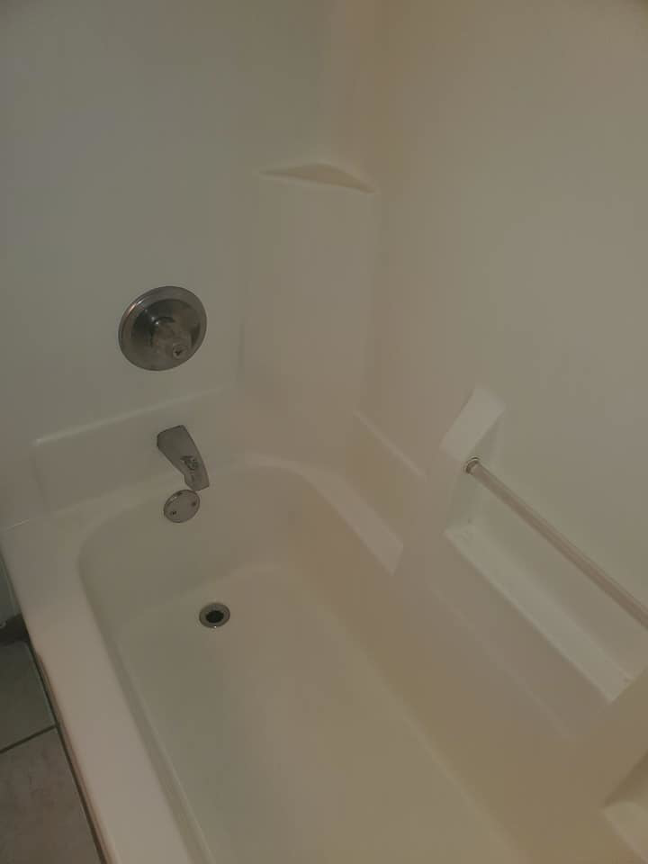 A sparkling clean white bathtub after professional cleaning service by Tip Top Cleaning in Champaign, IL.