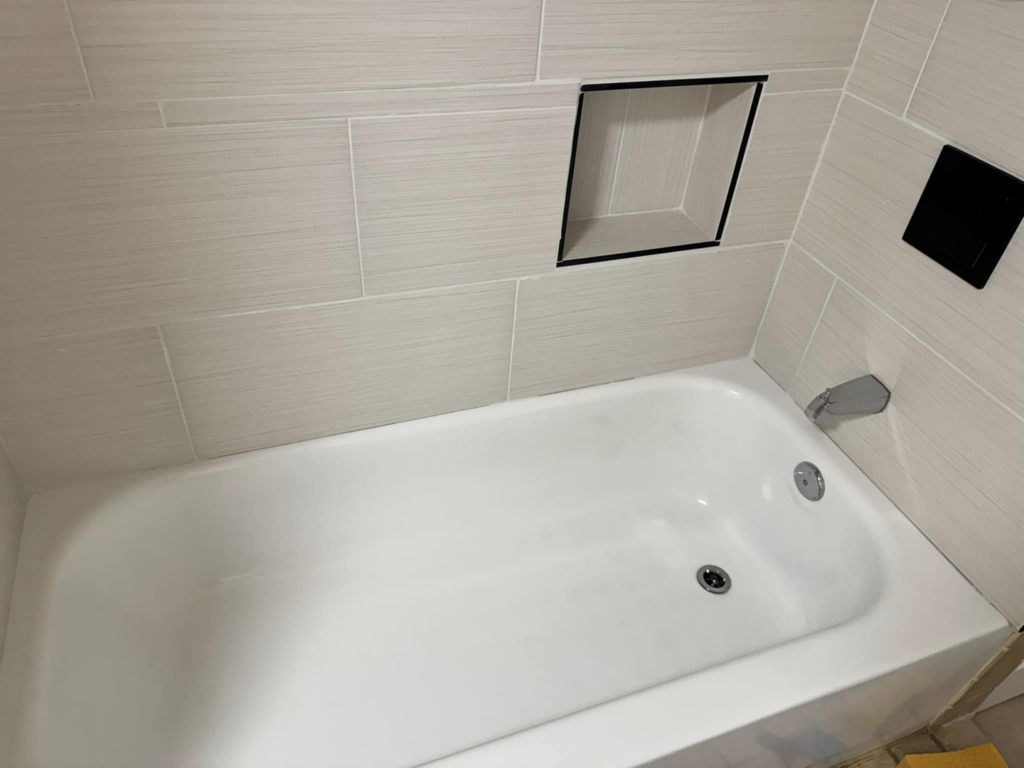 A sparkling clean bathtub and tiled shower wall, expertly cleaned by Dust Detail Cleaning Services in Post Falls, ID.