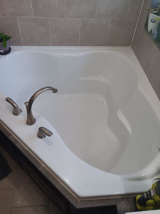 A sparkling clean bathtub with bronze fixtures, showcasing professional house cleaning by Hey Sis Cleaning LLC in Edmond, OK.