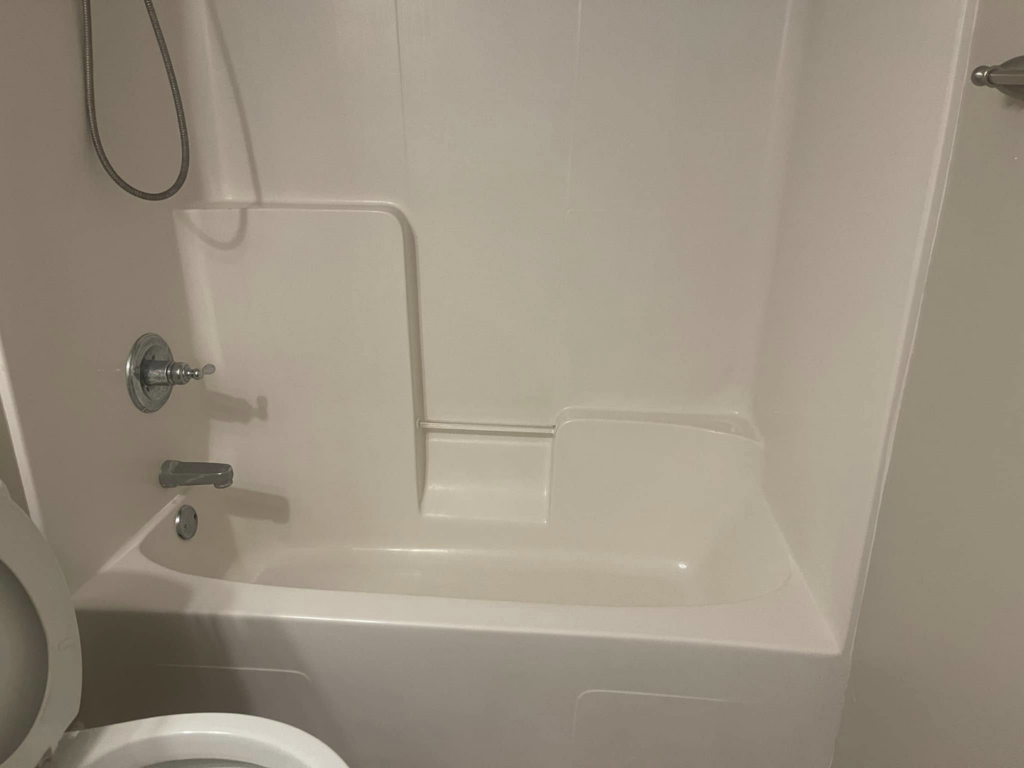 A sparkling clean white bathtub and shower area, showcasing the bathroom cleaning expertise of The Clean Solution in Eagle Lake, TX