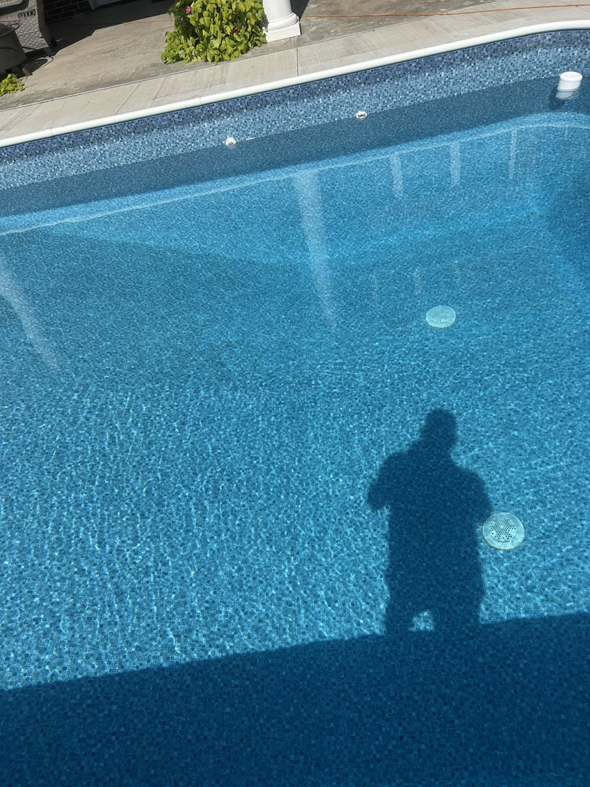A sparkling clean, blue in-ground pool, showcasing the excellent results of Pips Pool Service in Enid, OK.