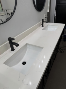 A sparkling clean double bathroom vanity with white sinks and black faucets by ClutterGone in Surprise, AZ.