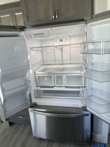 An open, sparkling clean and empty refrigerator, demonstrating a deep cleaning service by Groove-By-Nature Cleaning in Idaho Falls, ID.