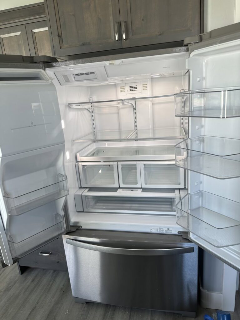 An open, sparkling clean and empty refrigerator, demonstrating a deep cleaning service by Groove-By-Nature Cleaning in Idaho Falls, ID.