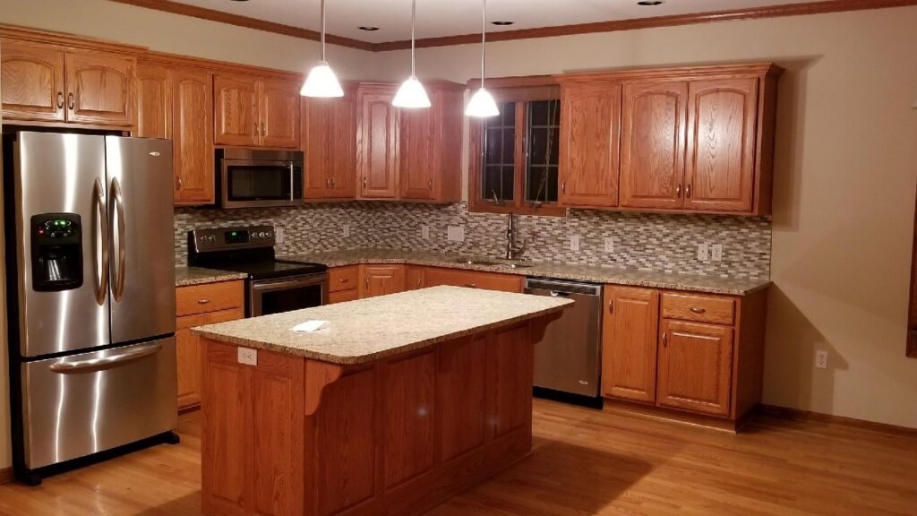 A sparkling clean kitchen with wooden cabinets and stainless steel appliances, showcasing Perfection Cleaning in Kansas City, MO.