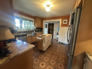 A sparkling clean kitchen with wooden cabinets and a unique penny-tiled floor by Green & Simple LLC in Puyallup, WA.