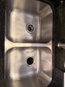 A sparkling clean stainless steel kitchen sink after professional cleaning by Jocelyn's Cleaning Services in Charlotte, NC.