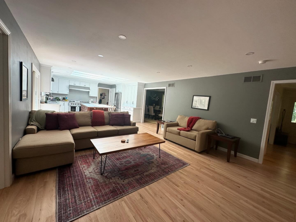 A spacious and sparkling clean living room and kitchen area, professionally cleaned by Mary's Sparkling Cleaning in Fall River, MA.
