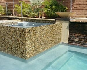 A sparkling clean pool and attached spa with decorative tile, showcasing the results of Pool Tile Cleaning Vegas in Las Vegas, NV.