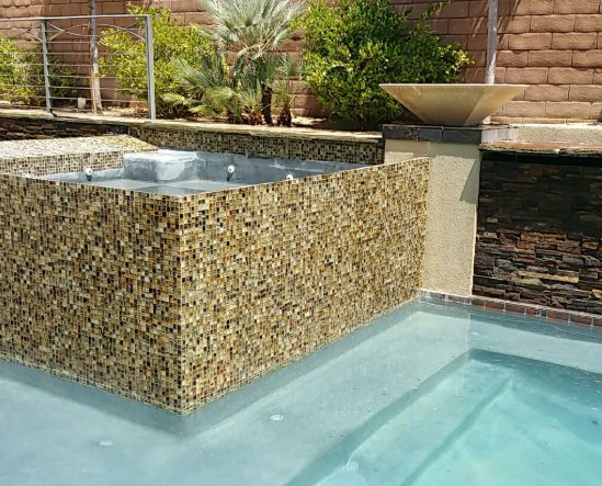 A sparkling clean pool and attached spa with decorative tile, showcasing the results of Pool Tile Cleaning Vegas in Las Vegas, NV.