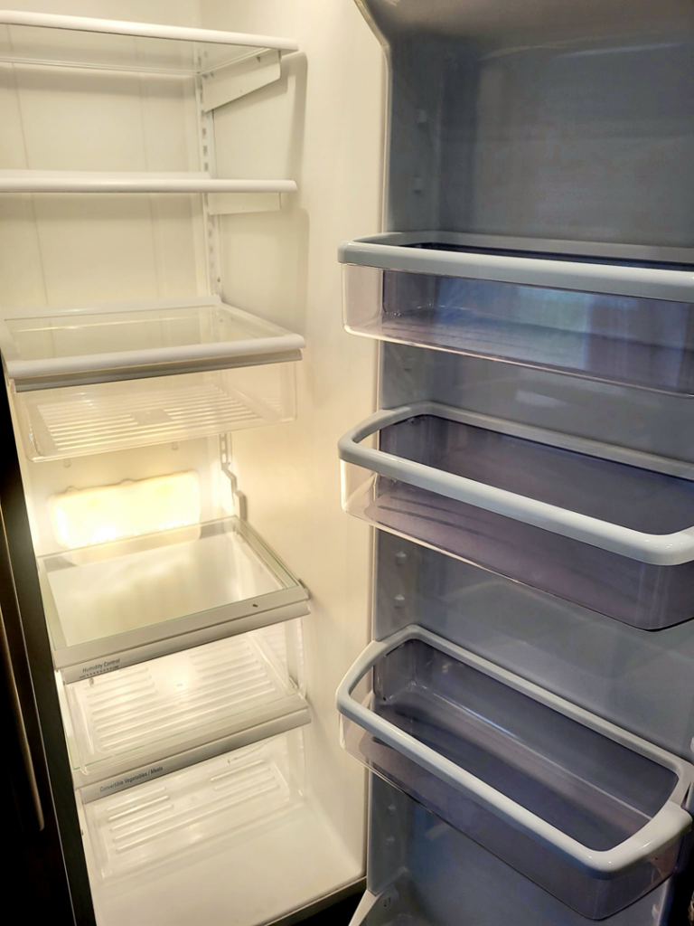 A sparkling clean and empty refrigerator, showcasing deep cleaning services by AMS Cleaning LLC in Iowa City, IA