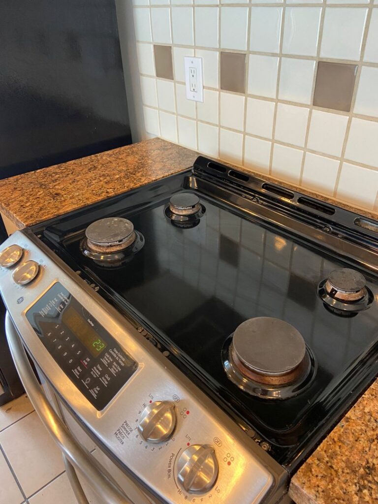 A sparkling clean stovetop with shiny burners, demonstrating Trust-Clean's thorough kitchen cleaning in Green Bay, WI.